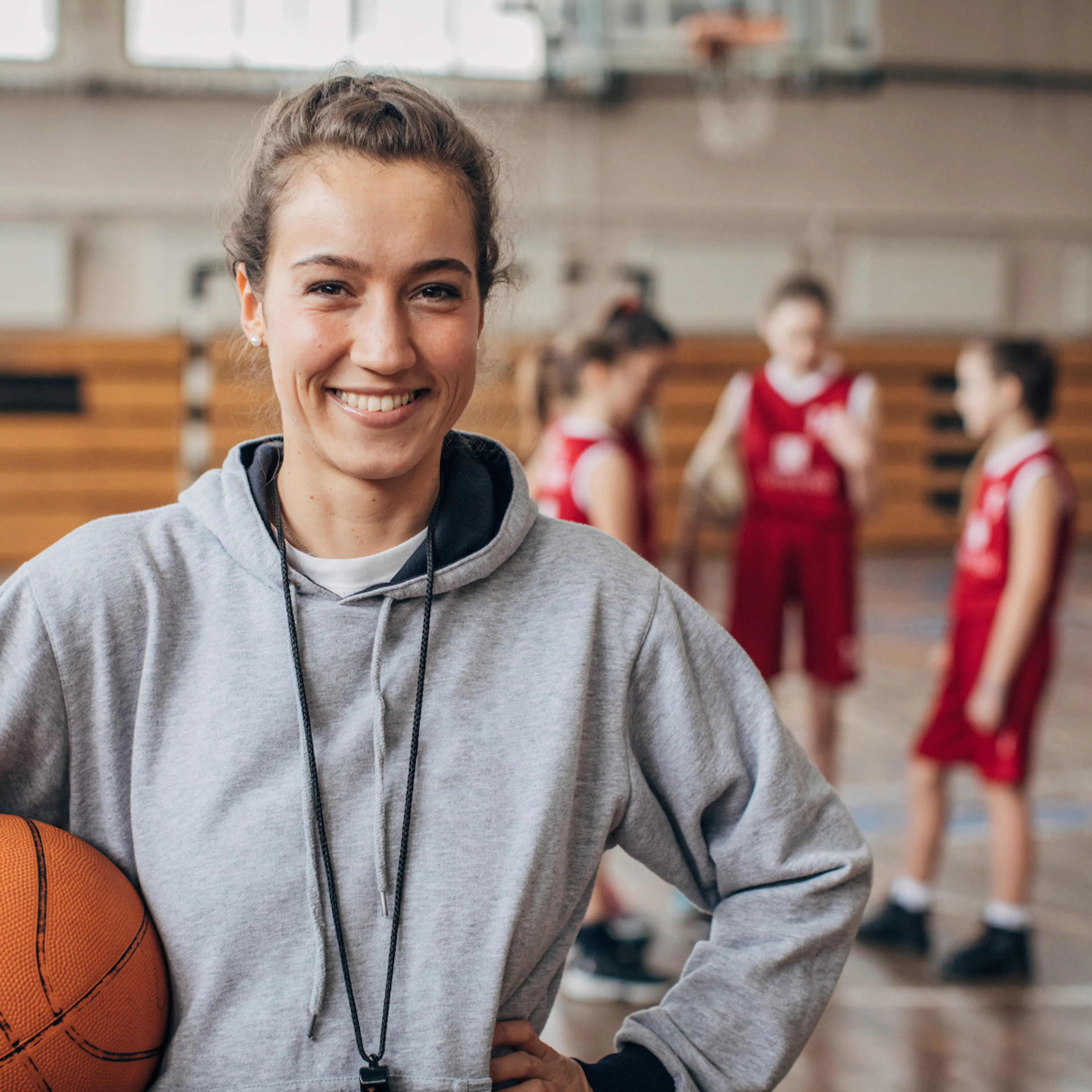 Volunteer coach smiling with their team, representing an unsung hero