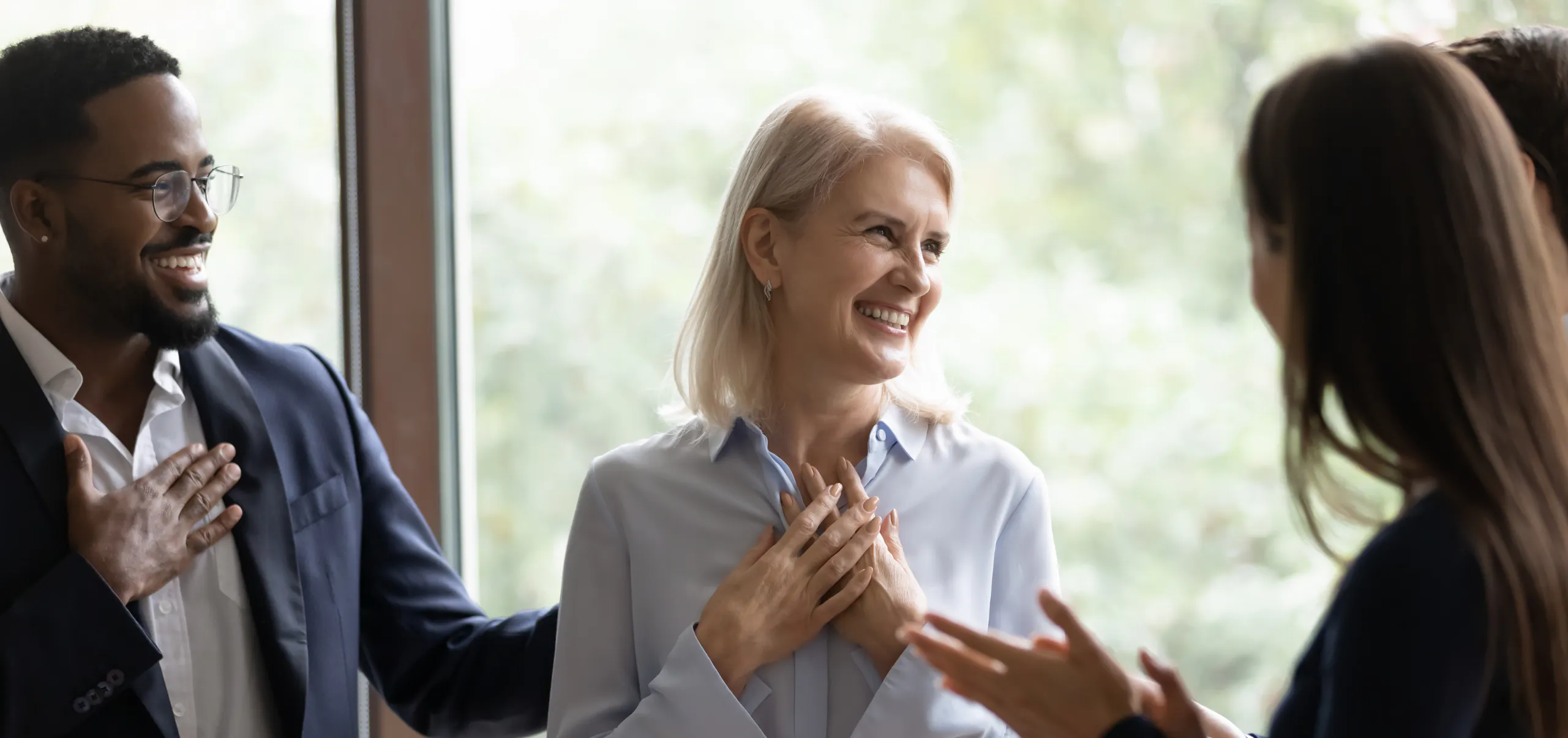 Woman smiling as she receives a genuine compliment from her coworkers