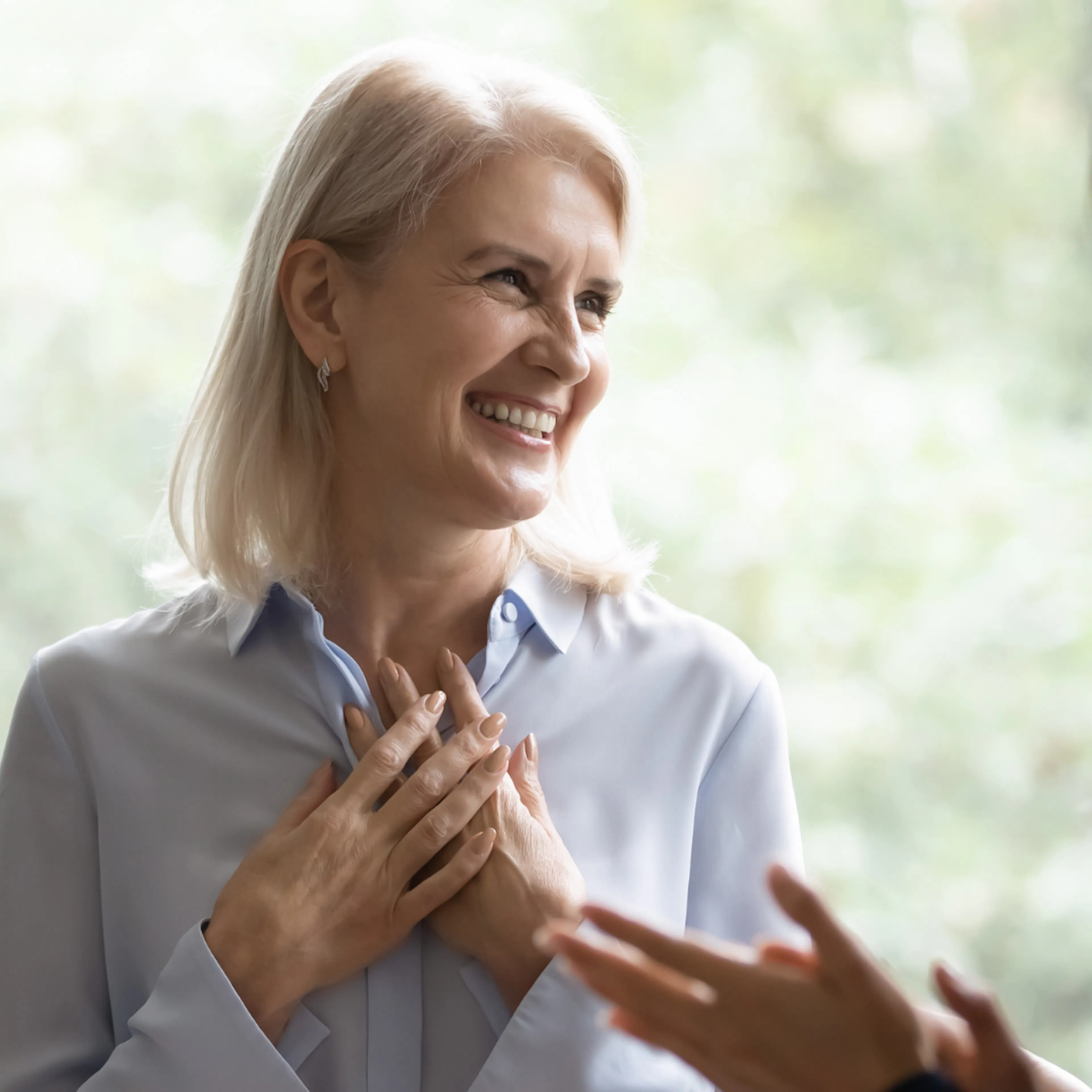 Woman smiling as she receives a genuine compliment from her coworkers