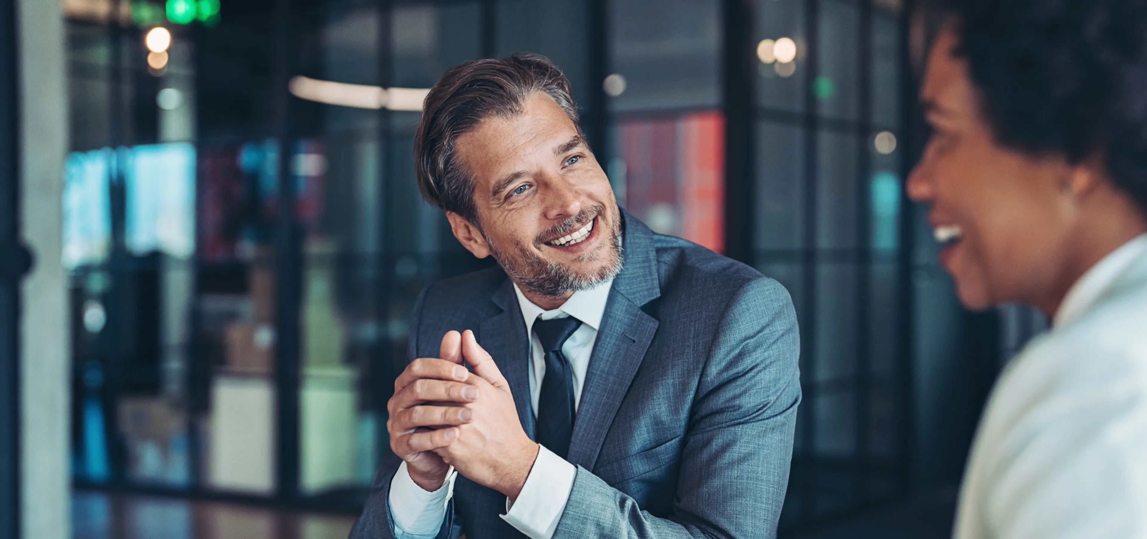 Man smiling as he receives a genuine compliment from his colleague
