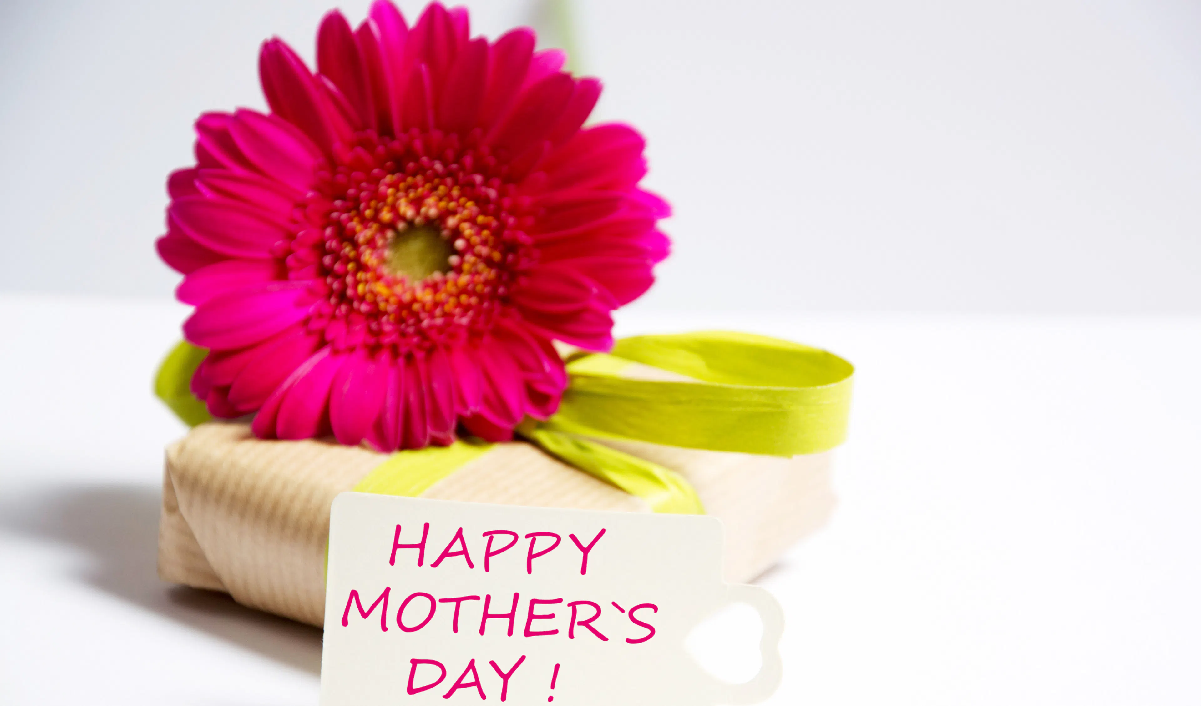 Thoughtful first Mother's Day gift wrapped in a box with a flower on top and Happy Mother's Day card