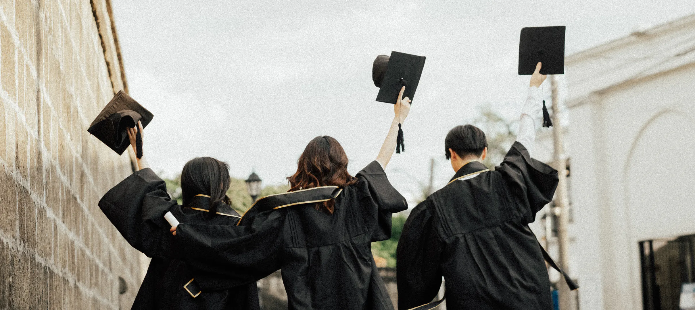 Grads in caps and gowns celebrating on graduation day