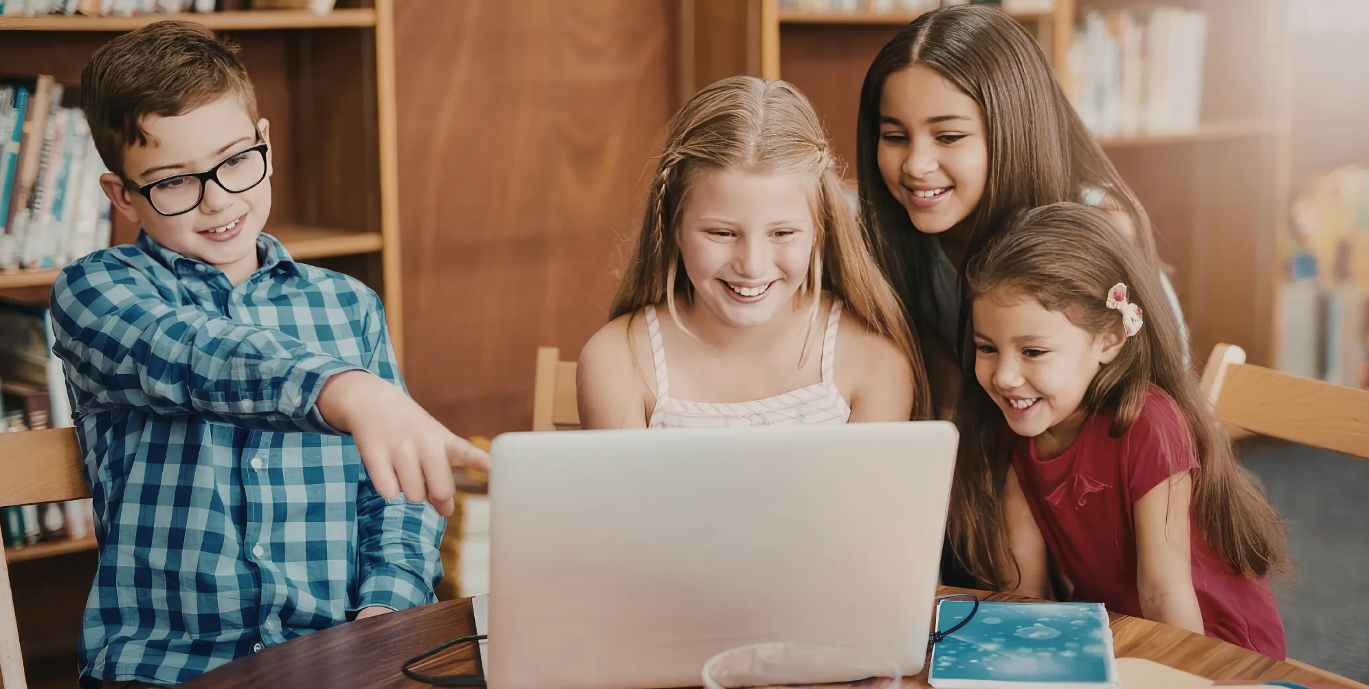 Kids gathered together at a laptop, representing making a group gift of messages for their teacher or coach