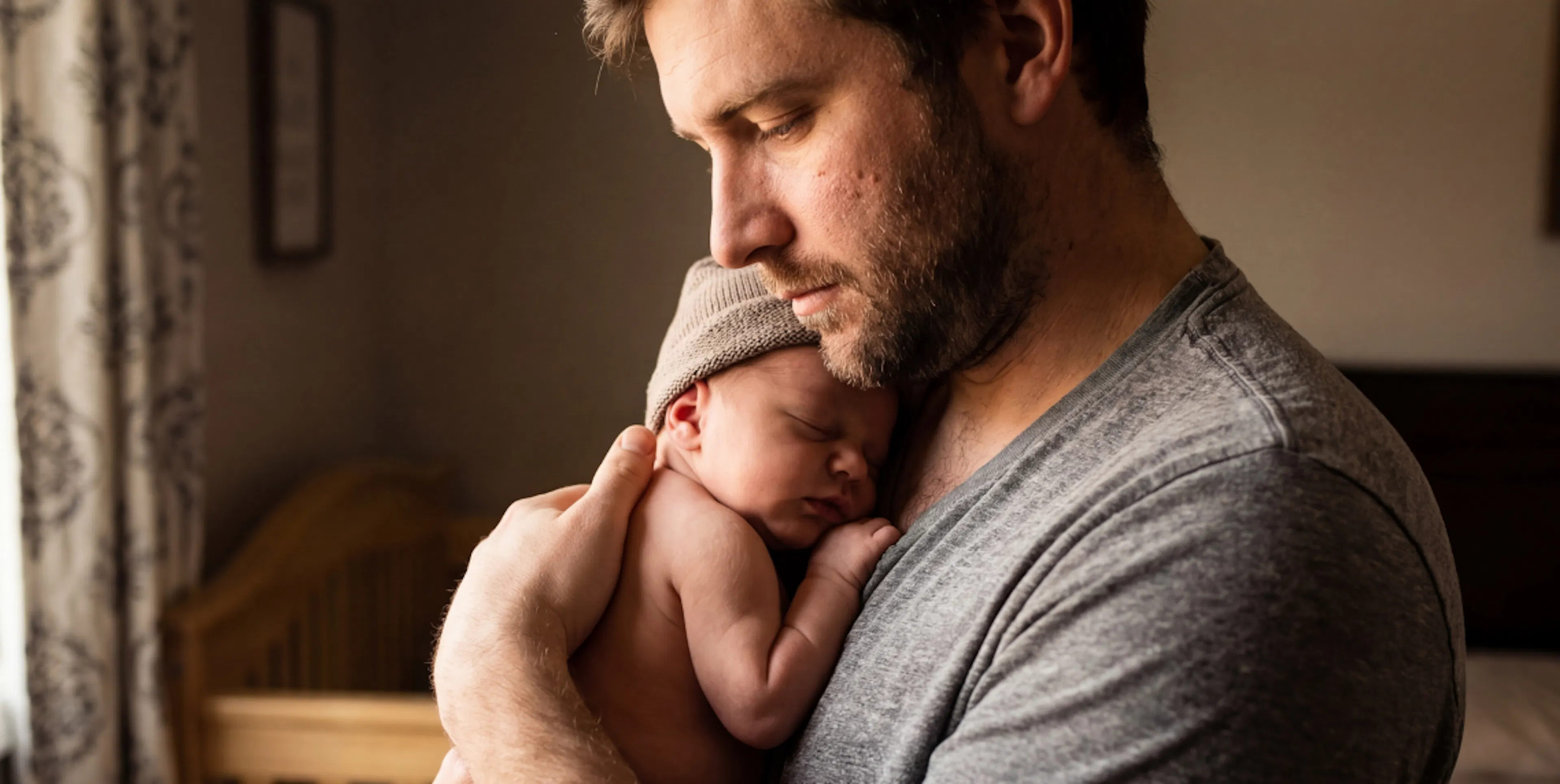 Father holding newborn baby, representing the moments and photos to preserve in baby's first year time capsule