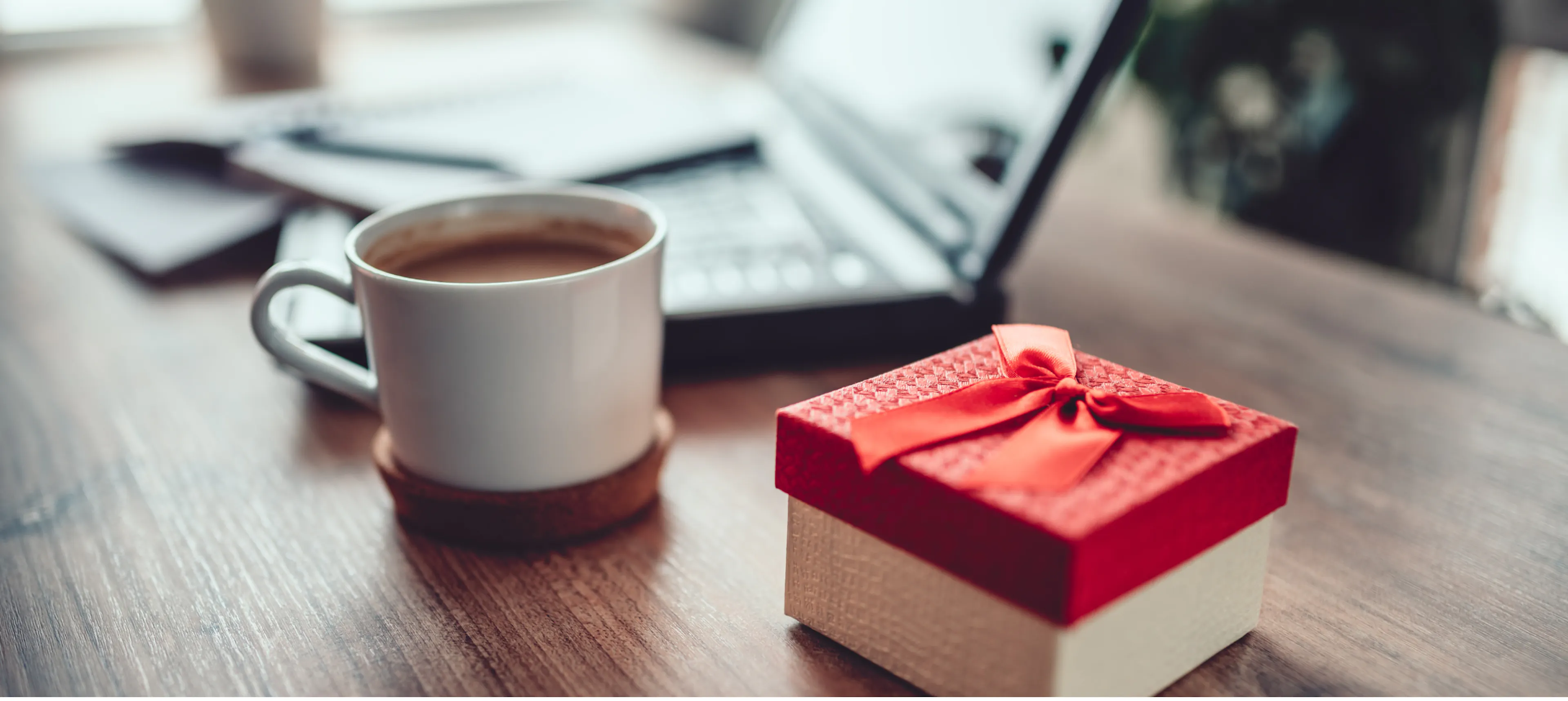 Co-worker gift on desk surrounded by coffee and laptop