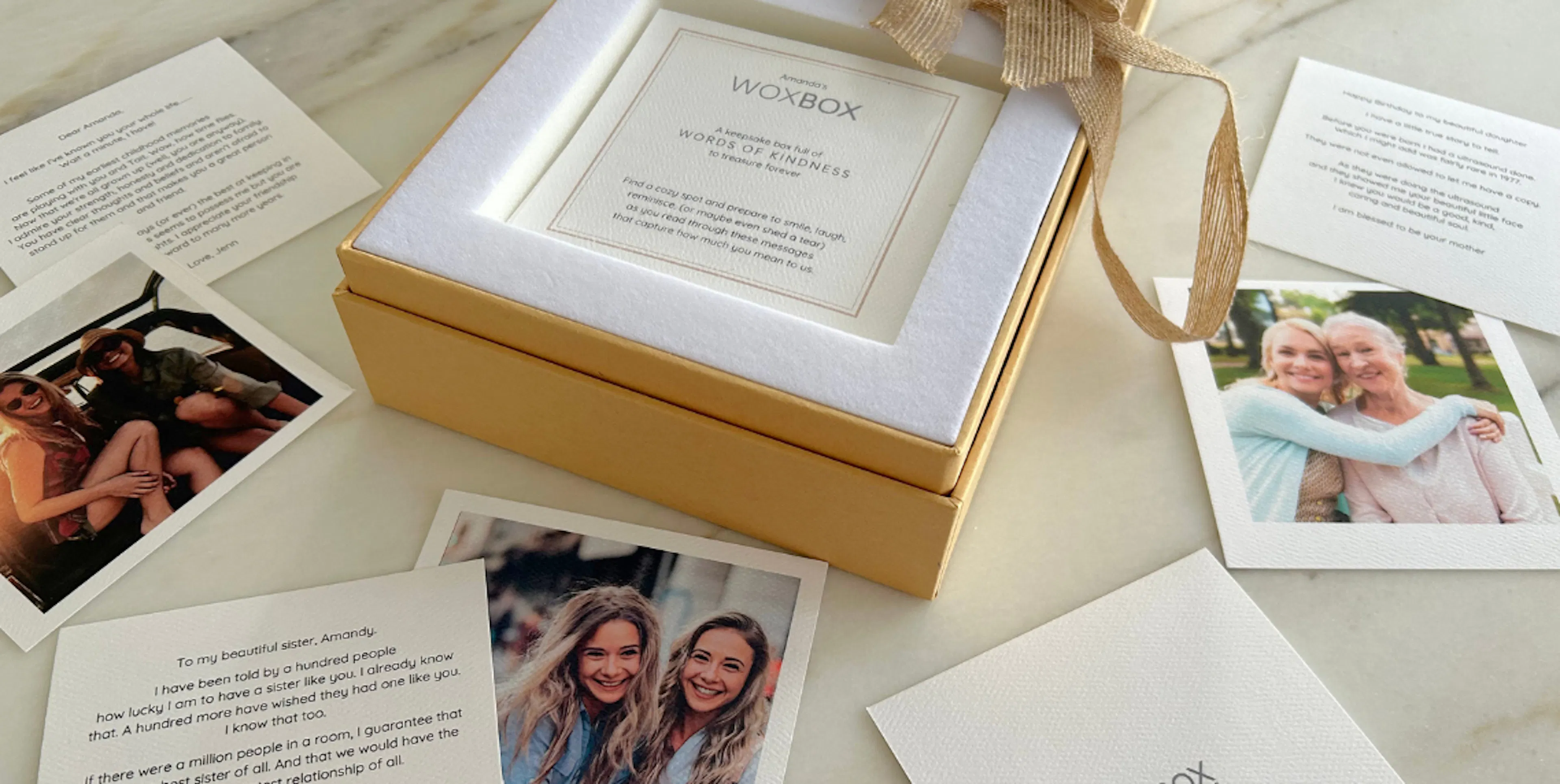 Printed note cards and photos on a counter with an open Woxbox, as part of a group gift