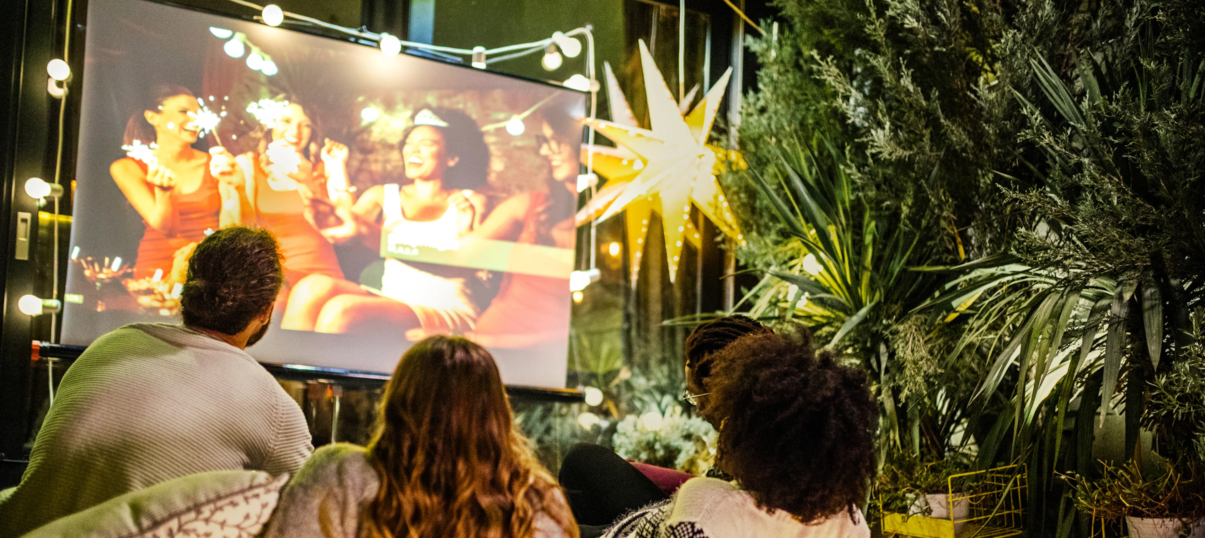 Family watching an outdoor movie together in their backyard as their summer tradition