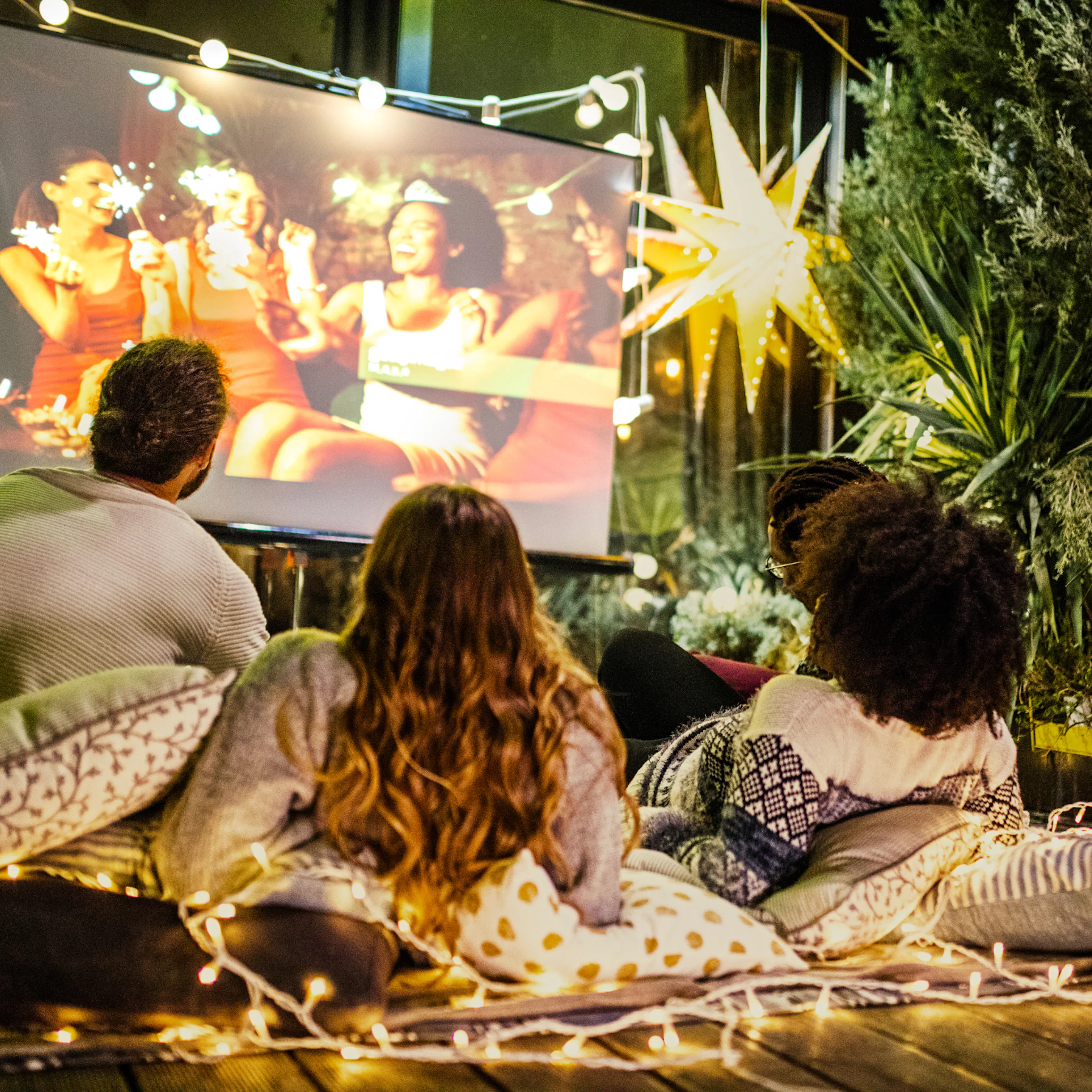 Family summer tradition of watching an outdoor movie together in their backyard