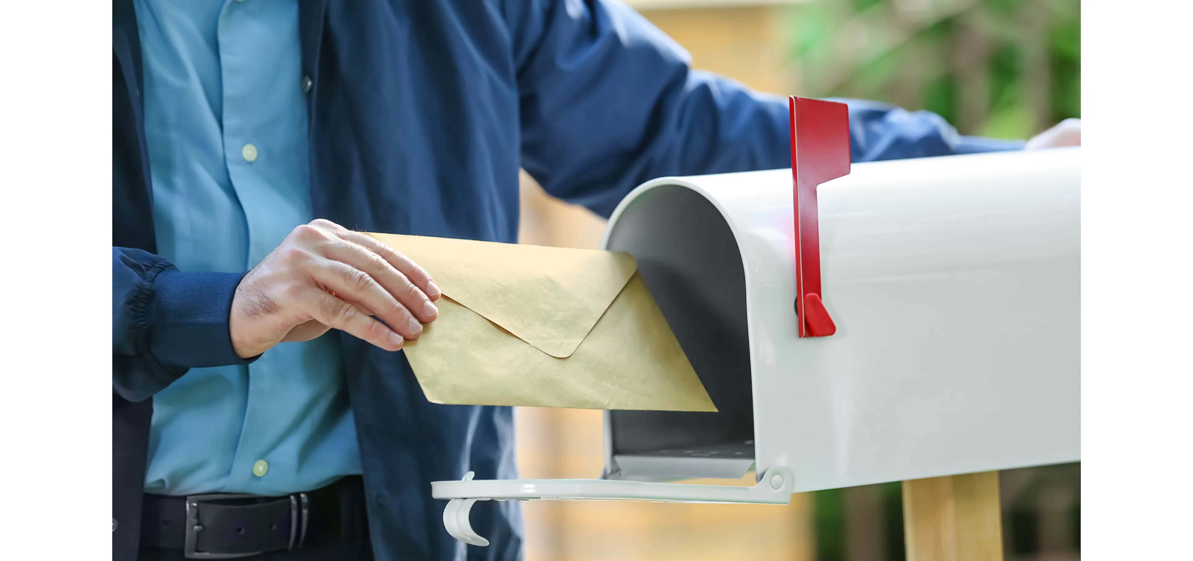 Person placing an encouraging card in a mailbox to send to someone starting a new chapter in a new city