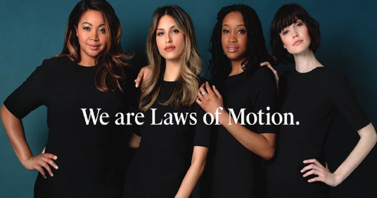 Four women stand together with the text "We are Laws of Motion."