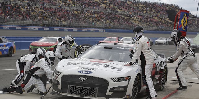 Wurth branded racing car and pitstop crew in a racing track