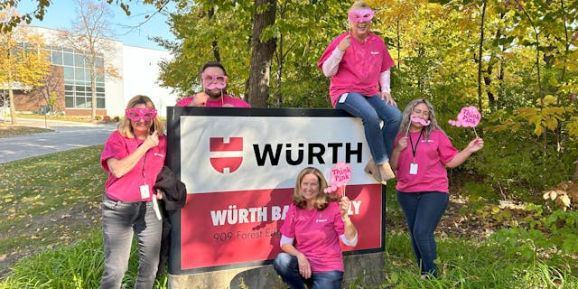 Wurth employees posing on a Wurth signage