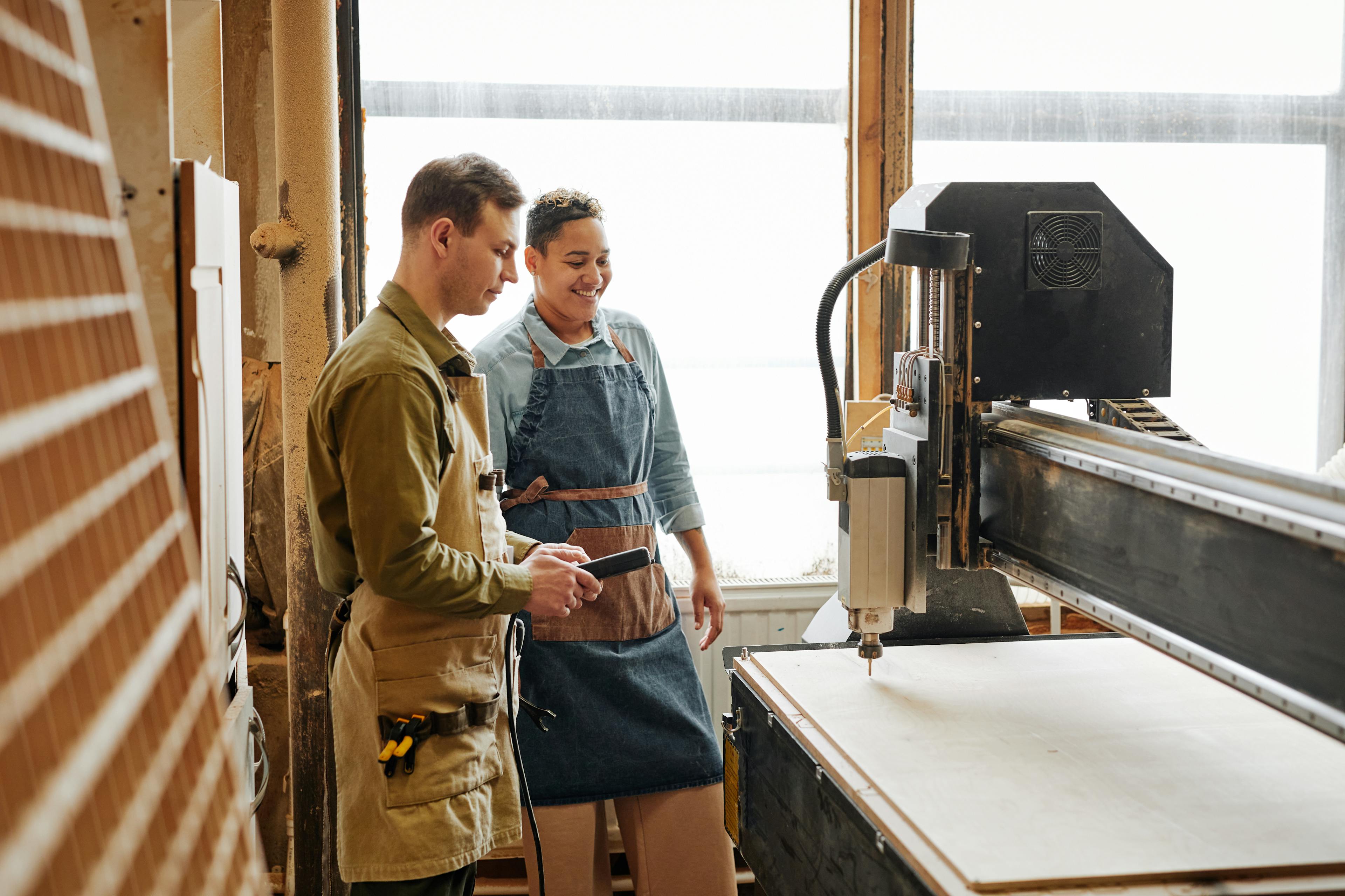 Two woodworkers looking at a machine