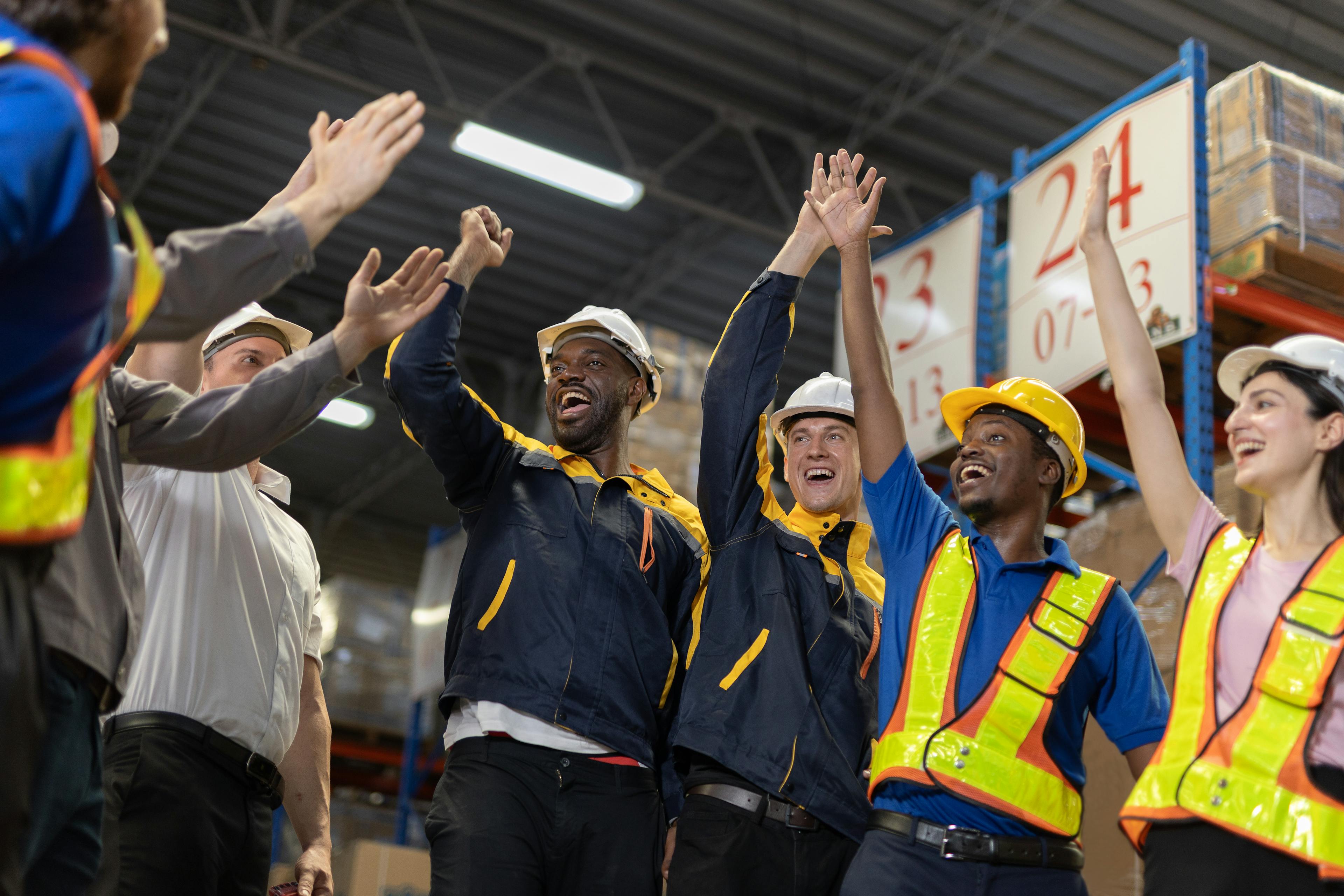 Warehouse workers happy and raising hands