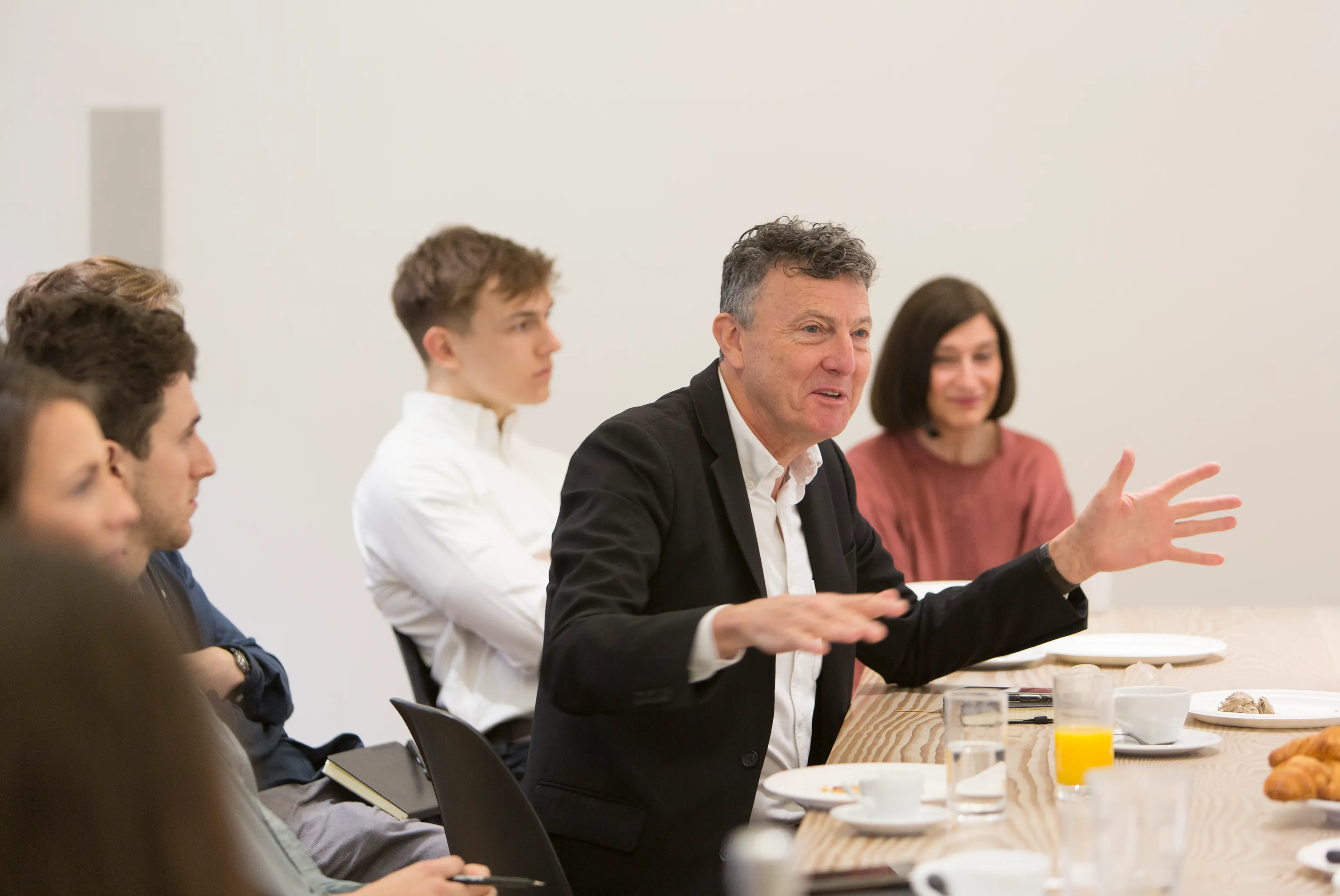 An image of Chris Williamson sitting at a table with team members expressing an idea.