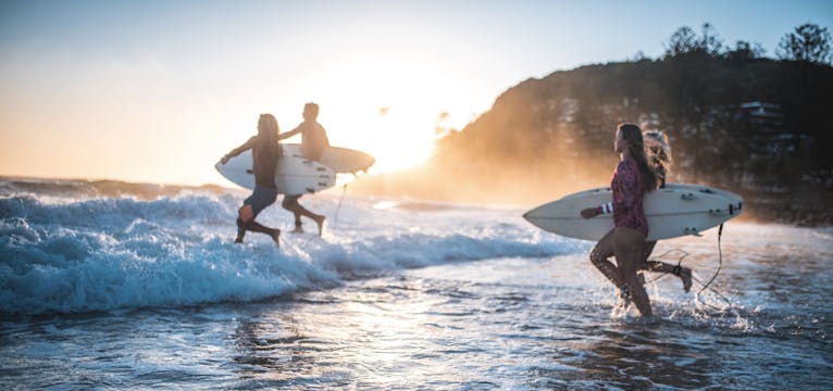 Surfers running into the water on the Gold Coast.
