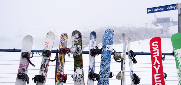 Snowboards lined up agains a fence in Perisher Valley, Australia.