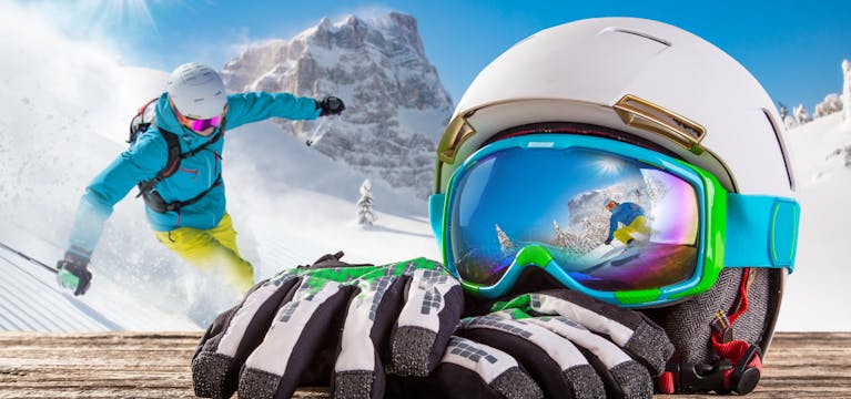 Ski equipment including white helmet, blue goggles and white and black gloves.