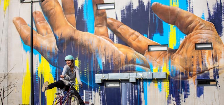 Cyclist in Christchurch in front of graffiti art.