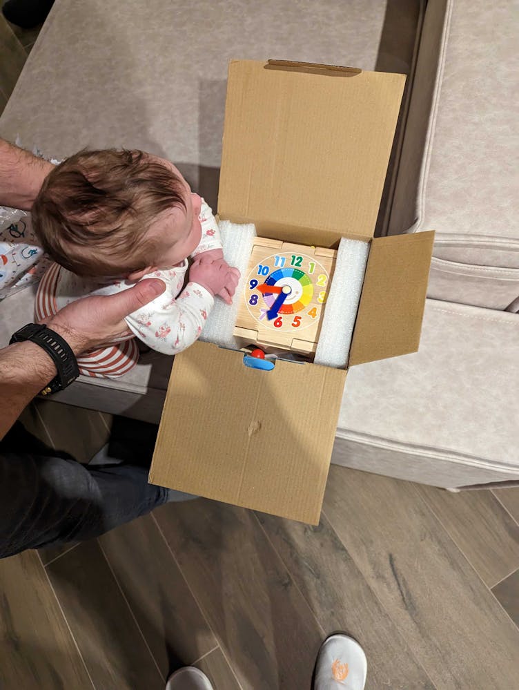 Photo of a Rozdoum’s colleague baby peering into a box filled with early years toys