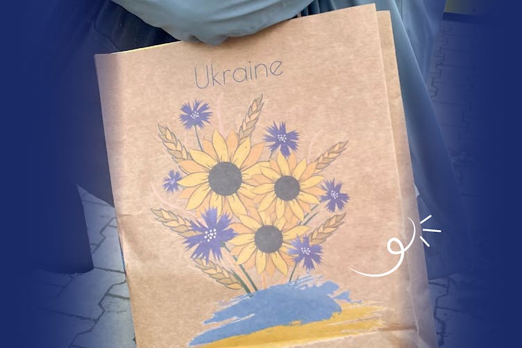 Adaptavist colleagues receive gifts from Rozdoum at the Ukraine/Poland border in paper bags with an illustration of sunflowers