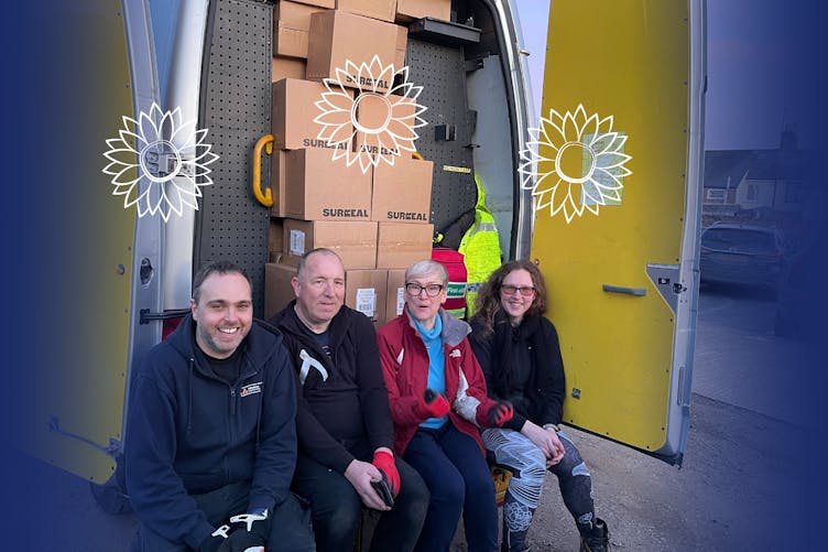 David, Phill, Lou M and Sandy sitting at the back of a transit van full of boxes of ready to drive to Ukraine/Poland border