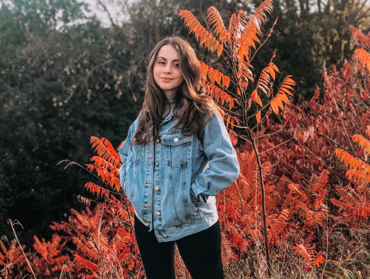 A photo of Jovanka in front of autumnal trees