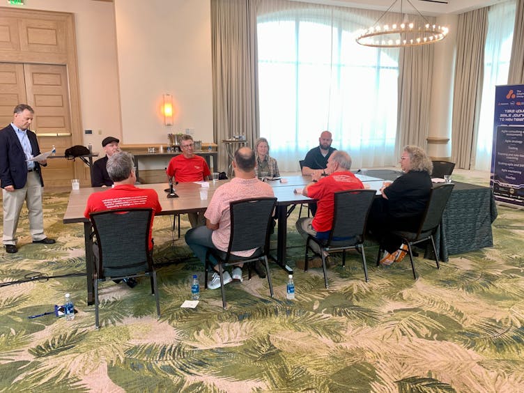 A group of agile experts around a table having a business discussion