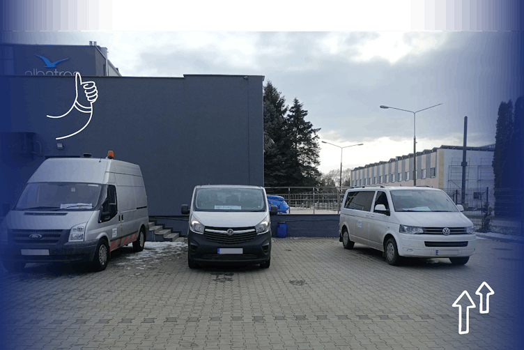 Two vans and a mini-bus in a carpark at the border ahead of exchanging paperwork for humanitarian aid to enter Ukraine