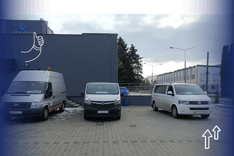 Two vans and a mini-bus in a carpark at the border ahead of exchanging paperwork for humanitarian aid to enter Ukraine 