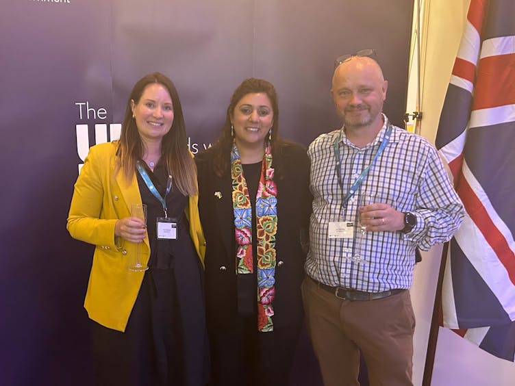 Ava and Jari with Nusrat Ghani, Minister of State, between the Ukraine and UK flags, in attendance at the UK-Ukraine TechBridge launch UK 