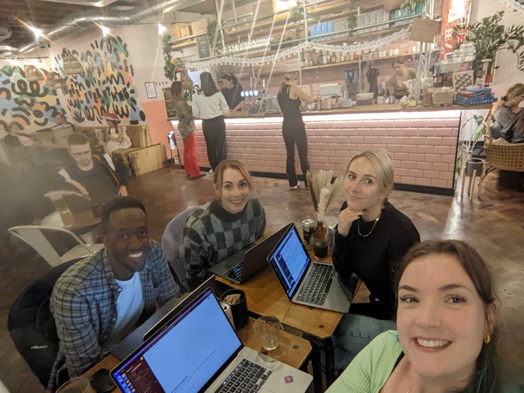 Romy working in a co-working space with three colleagues