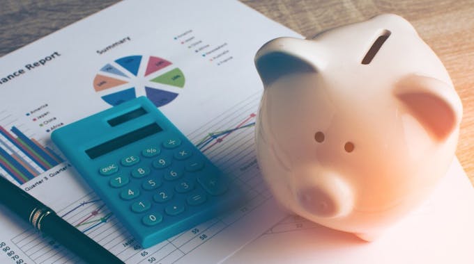 Sparschwein neben Taschenrechner und Bankunterlagen
