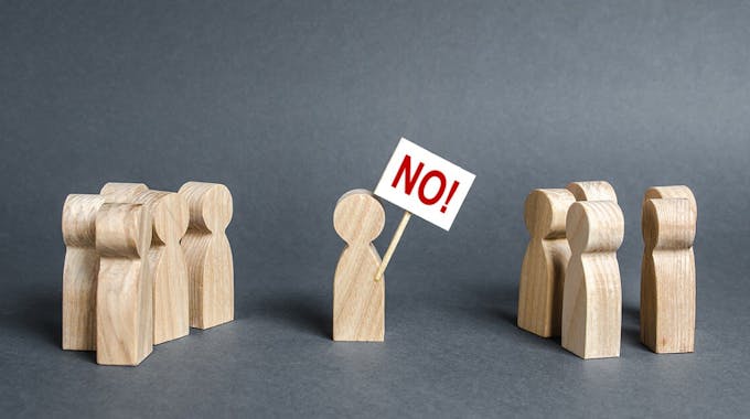 Holzfigur hält Verbotsschild