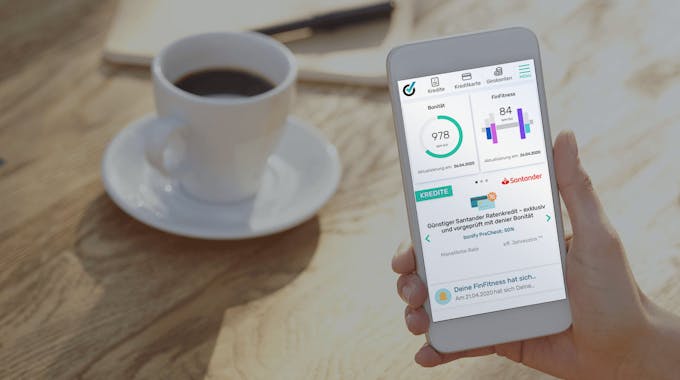 bonify Dashboard auf Smartphone neben einer Tasse