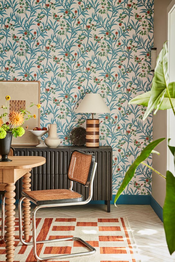 Dining space featuring blue and neutral floral wallpaper (Bamboo Floral - Heat) with a wooden dining table and chair.