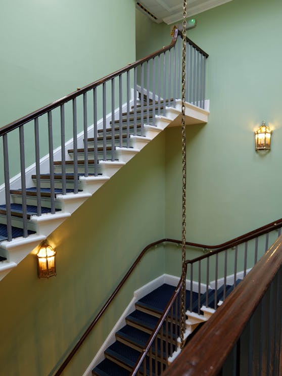 Staircase inside the Horse Guards building featuring bespoke pea green (Horse Guards Green) painted walls.