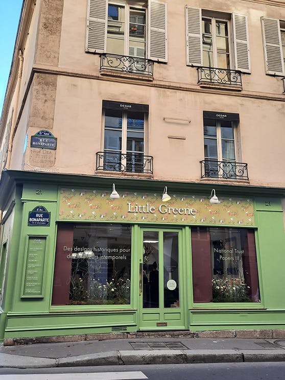 The Pea Green exterior of the Little Green Paris showroom located on the ground floor of a multi-storey building.