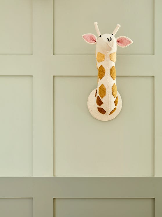 Giraffe wall decor on a green wall, with the top half in Green Stone - Light and the bottom half in darker Green Stone.