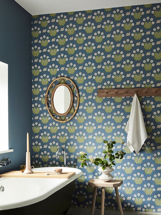 Bathroom with snail-printed wallpaper (Burges Snail - Juniper) on back wall and deep blue (Juniper Ash) on right wall.