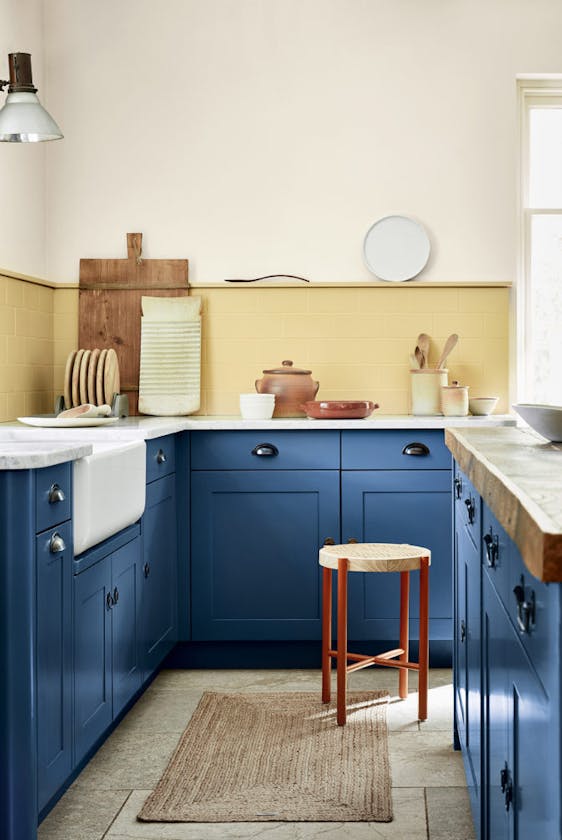 Kitchen with deep indigo (Woad) kitchen units and contrasting yellow tiles and upper wall.