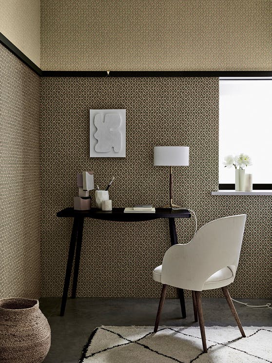 Indoor study with two shades of small scale wallpaper 'Moy' (Lime and Pompeian Ash) with a black desk and white chair. 