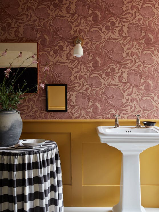 Bathroom with pink floral wallpaper (Poppy Trail - Masquerade) on the upper wall and yellow on the bottom half (Yellow-Pink). 