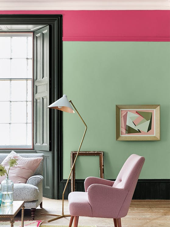 Living room painted in light green 'Pea Green' with a bright pink contrast stripe and pale pink chair.