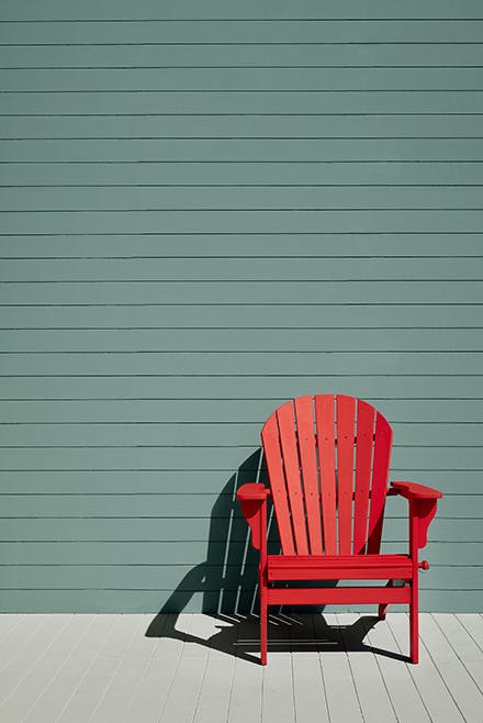 Exterior paneled wall in green-blue shade (Pleat) with a bright Atomic Red chair and neutral Cool Arbour paneled floor.