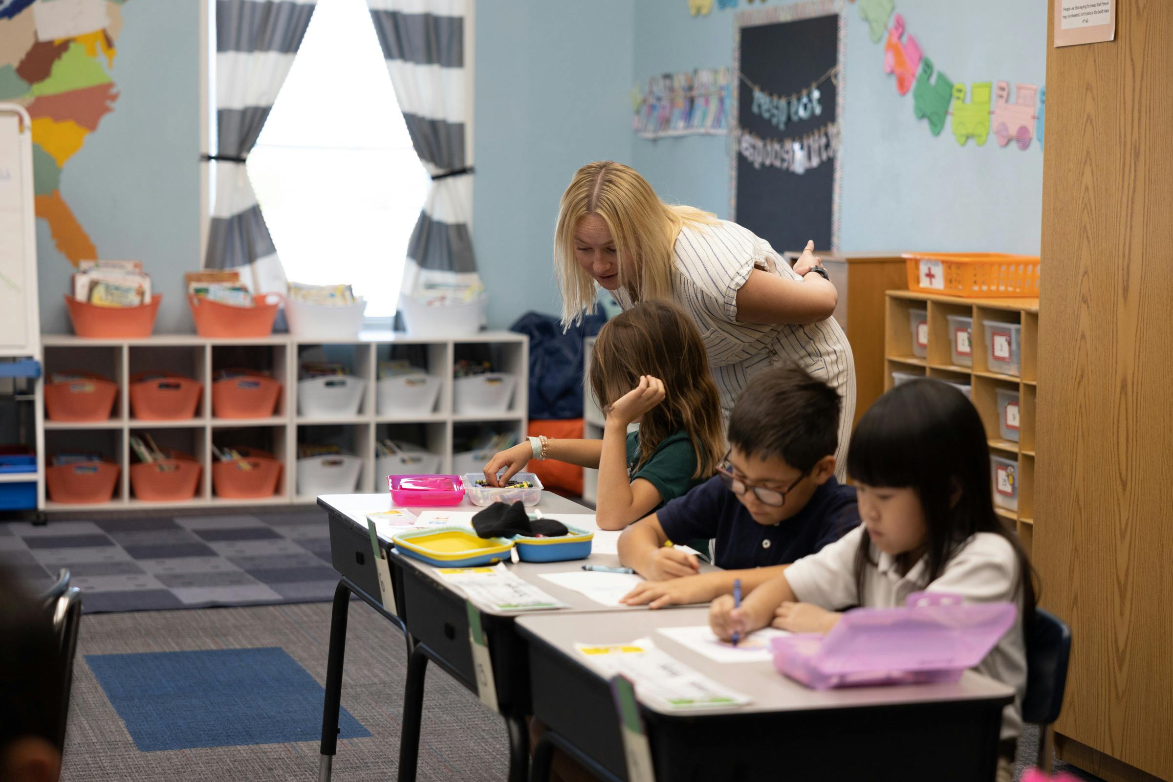 Teacher helping out a student in a classroom
