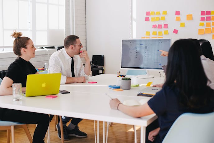 Team sitting around desk looking at screen
