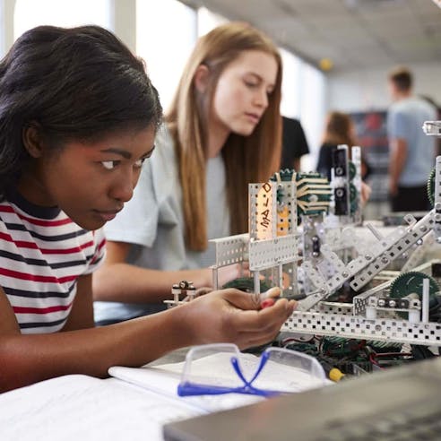 Students building a machine on desktop