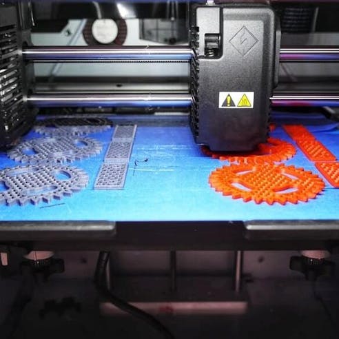 Large gray and orange 3D printed parts. Image Credit: Shutterstock.com/Cheshiry_cat
