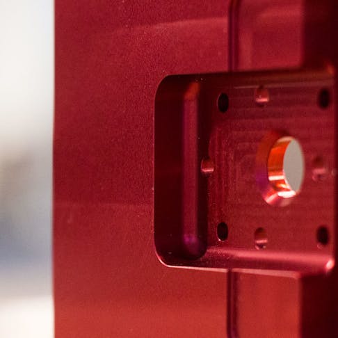 side of red CNC machined part